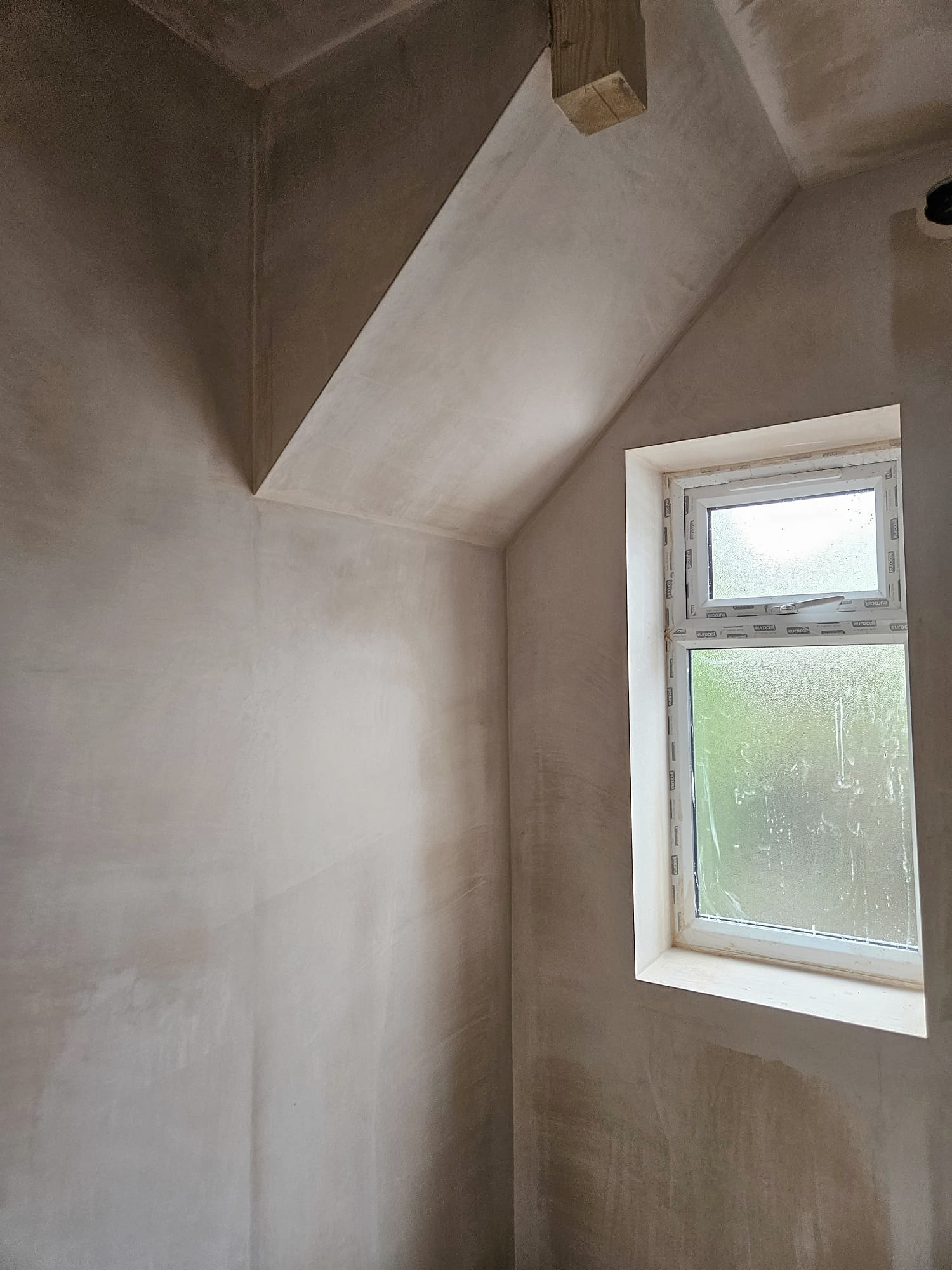 Sloped-ceiling bathroom skimmed around the window by D Whitley Plastering